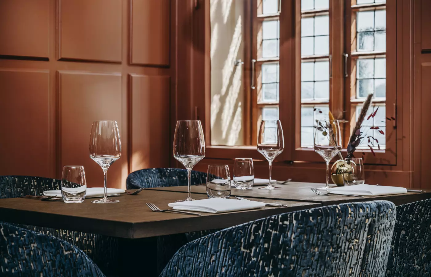 Ein schön gedeckter Tisch steht unter einem hellen Fenster im Restaurant in Büsum
